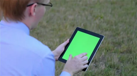 Man using digital tablet computer touchscreen with a green screen Vidéo 68057110