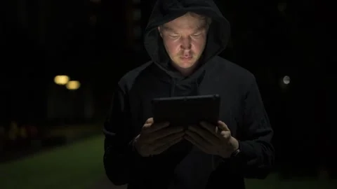 Man using digital tablet computer outdoors at night while thinking alone Stock Footage 317369148