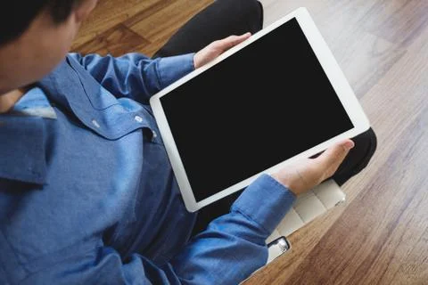 A man using digital tablet computer, sitting on chair, clipping path screen Foto stock