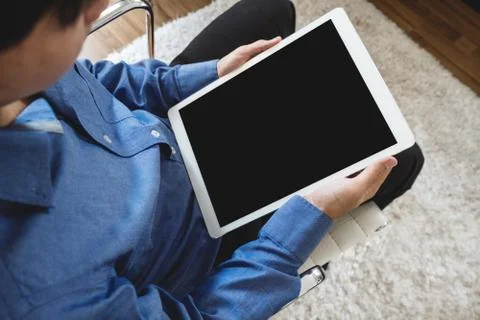 A man using digital tablet computer, sitting on modern chair Stock Photos