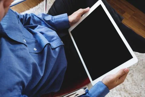 A man using digital tablet computer, sitting on modern chair Stock Photos