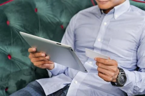 Man using a digital tablet on a couch Stock-Fotos