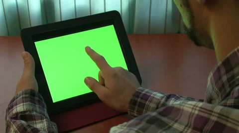 Man using digital tablet with a green screen to add your own custom content Video stock 32879367