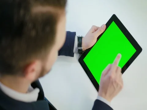 A Man Using an Digital Tablet with a Green Screen Stock Footage 84769230