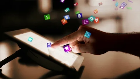 Man using a digital tablet with holographic app icons flying from it. Brown. Stock Footage 83143047