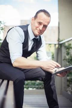 Man using digital tablet outdoors, smiling, portrait Stock Photos