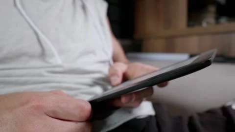 Man Using Digital Tablet to Read E-Book While Relaxing at Home Stock Footage 339217787