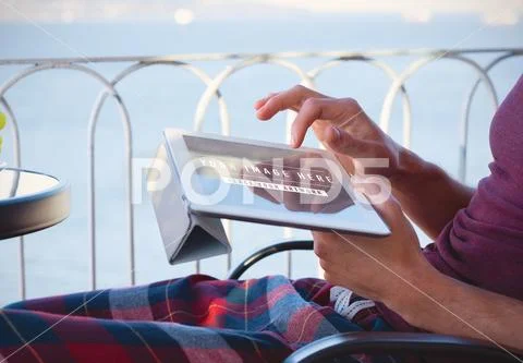 Man using digital tablet on terrace Mockup PSD Template