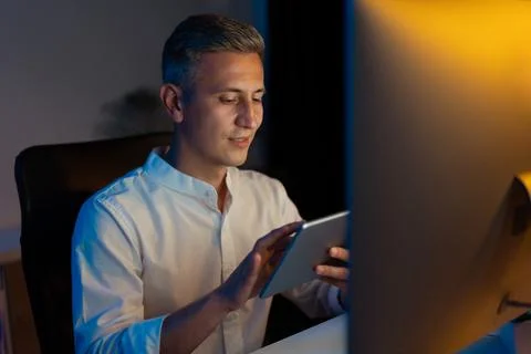 Man Using Digital Tablet at Work in Modern Office at Night Stock Photos
