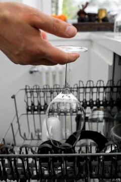 A Man using a dishwasher in a modern kitchen. domestic appliance Photos