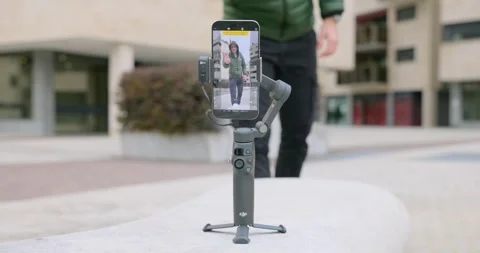 A Man Is Using A DJI Osmo Mobile 7P, Smartphone Gimbal Stabilizer. Selective Video stock 306855851