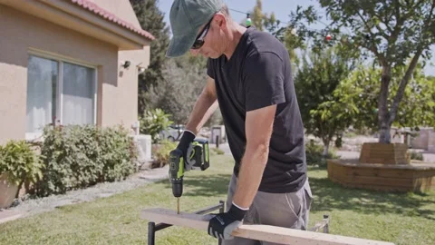 Man using a drill to make a hole in a piece of wood - slow motion Video stock 139577692