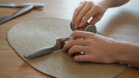 Man using a dual-sided roller sharpener for a two-step knife sharpening Stock Footage 315209383