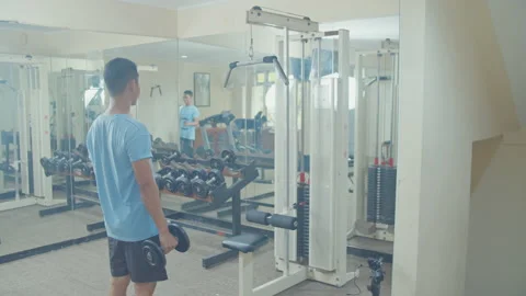 A Man Using Dumbbell in Small Gym Stock Footage 162207524