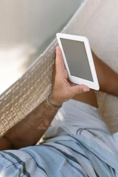 Man using a e-book while relaxing in a hammock Stock Photos