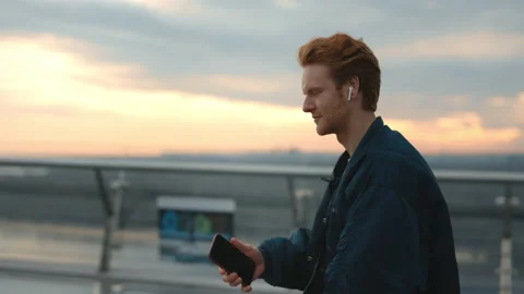 Man using earphones and mobile for listening music outdoors Stock Footage 162618084
