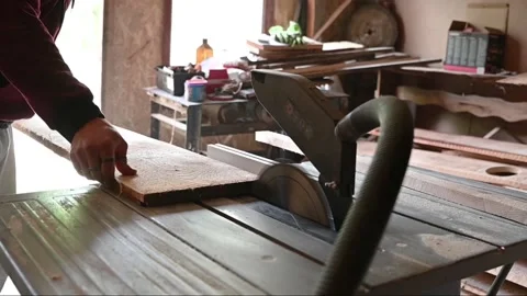 Man using an electric circular saw table to cut a wood plank during pandemy of Stock Footage 131055666