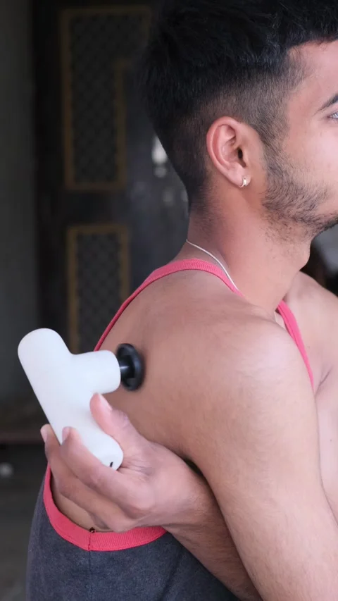 Man using electric massage gun on back for muscle relief and recovery Stockbeeldmateriaal 331062941