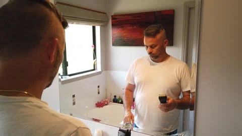 Man using electric razor in the mirror, shaving in the morning, getting Stock Footage 121875152