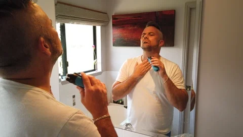 Man using an electric razor to trim his short stubble and give it a Stock Footage 121870339