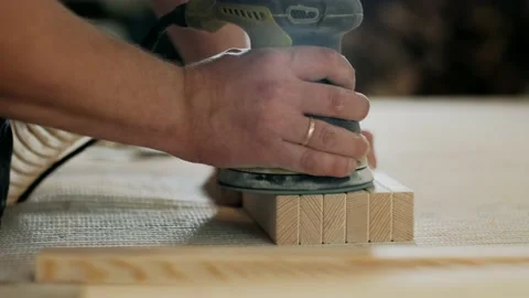 Man Using Electric Sander for wood in a carpentry workshop. Stock Footage 143385842