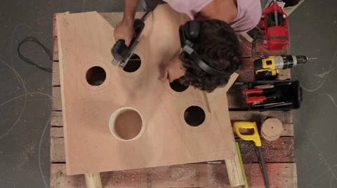 Man using electric saw to cut circles in wood. Stock Footage 46742434