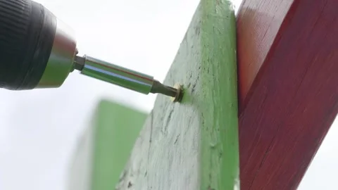 Man Using Electric Screwdriver to Install Screws in Playground Stock Footage 293344081