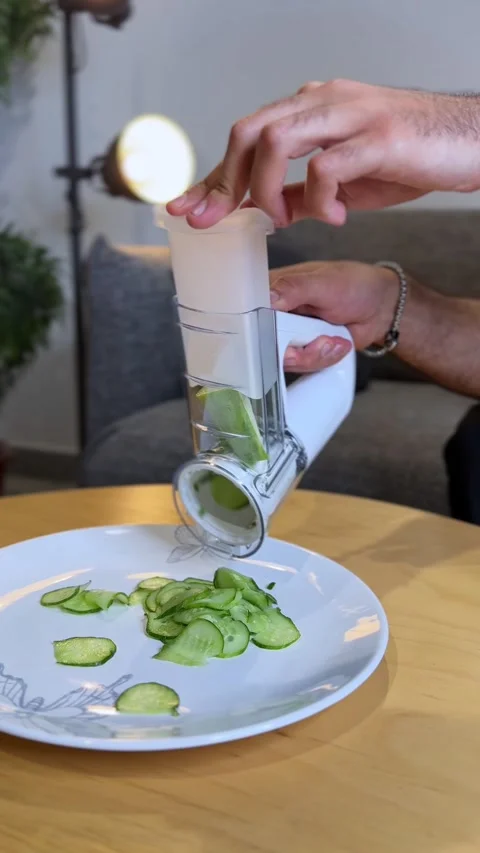 Man using electric vegetable slicer for cucumber Stock Footage 334409017