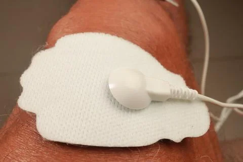 Man using an Electro Therapy Massager or Tens Unit on his knee Stock Photos