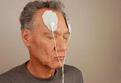 Man using an Electro Therapy Massager or Tens Unit on his forehead Stock Photos