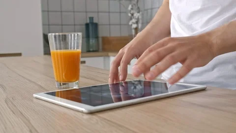Man using electronic tablet pc in kitchen. Man searching food recipe in tablet Stock Footage 97661192
