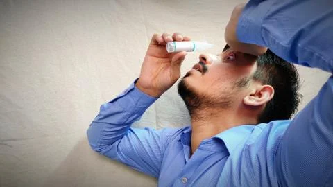 Man using eye drop for sure pain relief Stock Photos