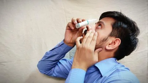 Man using eye drop for sure pain relief Stock Photos