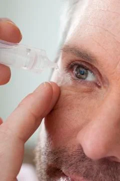 Man using eye lotion Stock Photos