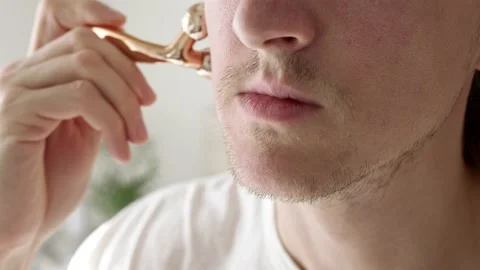 Man using face roller Stock Footage 222791037