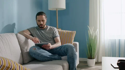 Man Is Using Gadget at Home Vídeo Stock 129888824