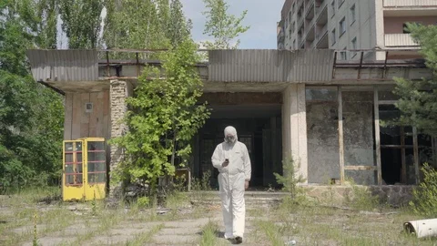 Man using a geiger counter with gas mask and protective suit in Pripyat Vidéo 86007580