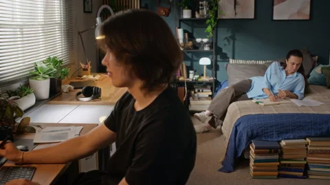 Man Using Graphics Tablet While Woman Studying in Bedroom Stock Footage 341940164