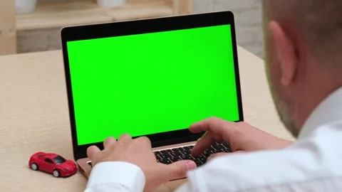 Man using green screen laptop near red car model. Buy and sell auto online Video stock 274218427