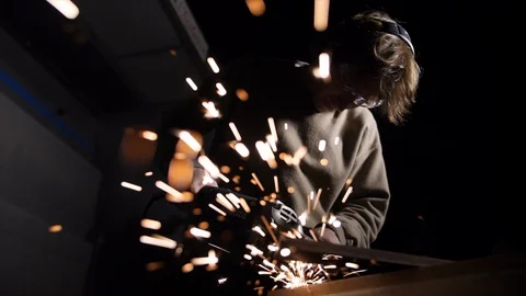 Man using a grinder with sparks flying over the camera in slow motion Stock Footage 127800625