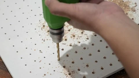 Man using hand electric drill to make holes on board plank, diy pegboard Video stock 290898263