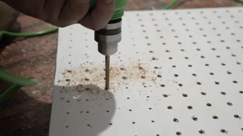 Man using hand electric drill to make holes on board plank, diy pegboard Video stock 290898288
