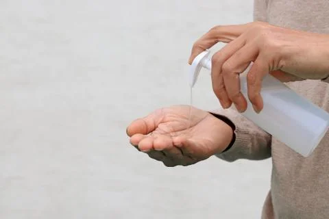 Man using hand press bottle and pouring alcohol-based sanitizer on other hand Foto stock