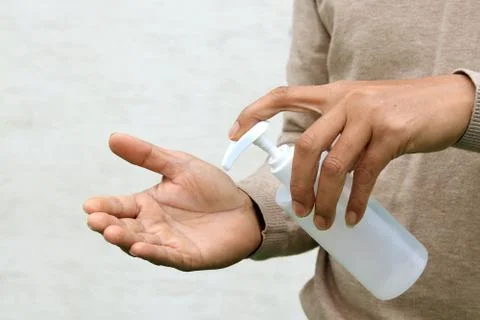 Man using hand press bottle and pouring alcohol-based sanitizer on other hand Foto stock