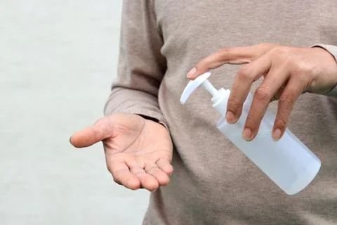 Man using hand press bottle and pouring alcohol-based sanitizer on other hand Foto stock