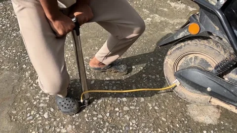 Man Using Hand Pump to Inflate Scooter Tire Closeup Stockbeeldmateriaal 317997778