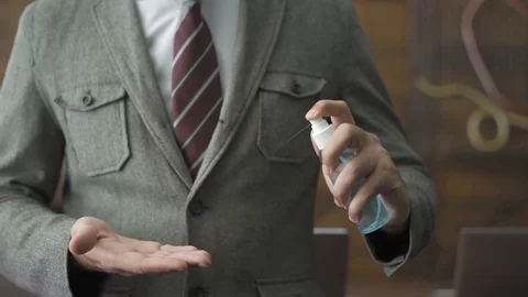 Man using hand sanitizer working in the office in pandemic days. Stock Footage 130043102