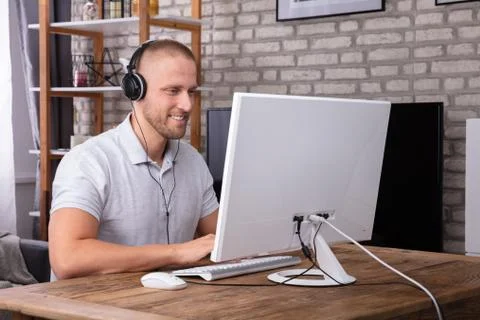 Man Using Headphone While Working On Computer Foto stock