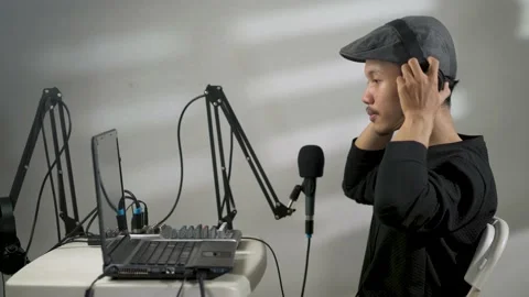 A man using a headset preparing to do a podcast Video stock 156028792