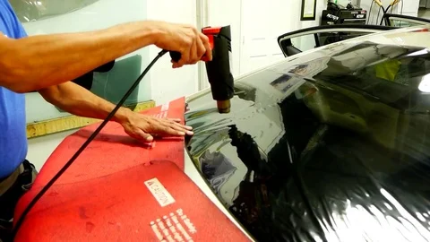 Man using heat gun on window tint Stock Footage 82311492